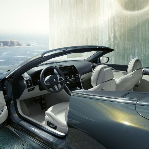 BMW M850i xDrive Cabrio, iç tasarım. Açık softtop ile metalik Gri/Dravit BMW M850i xDrive Cabrio, M deri direksiyon ve Fildişi Beyazı “Merino” BMW Individual deri döşemeyi içeren iç tasarım.