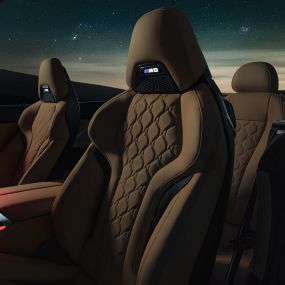 “Merino” deri M Sport koltuklar. “Merino” deri M Sport koltuklar ve kırmızı ortam aydınlatmasıyla yıldızlı gökyüzü altında açık softtop ile BMW M8 Competition Cabrio.