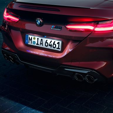 BMW M8 Competition Cabrio, yakın çekim. Metalik Kırmızı/Motegi BMW M8 Competition Cabrio, LED stop lambaları ve M8 Competition isimliğine yakın çekim.