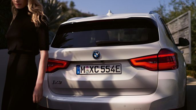 BMW i’ye özel difüzör ile arka bölüm BMW iX3 G08 kadın ve arkadan görünüm BMW i’ye özel difüzör ile arka bölüm BMW iX3 G08 Metalik Beyaz/Mineral kadın ve arkadan görünüm