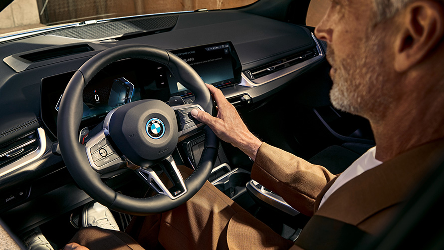 BMW 2 Serisi Active Tourer U06, BMW iDrive BMW 2 Serisi Active Tourer U06, BMW iDrive, BMW İşletim Sistemi 8, direksiyonu tutan bir adamla birlikte kokpitin görünümü