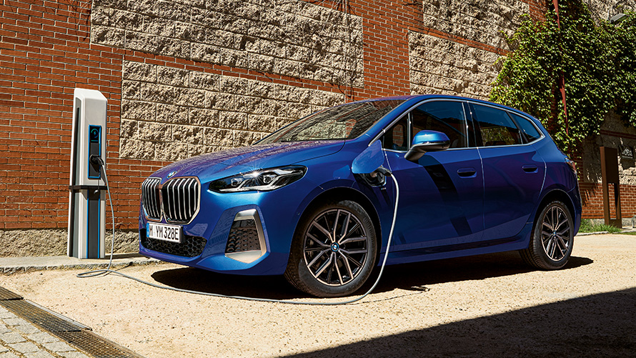 BMW 2 Serisi Active Tourer plug-in hybrid U06, şarj istasyonunda görünüm BMW 2 Serisi Active Tourer 230e plug-in hybrid U06, Metalik M Mavi/Portimao, şarj istasyonunda yan çaprazdan görünüm
