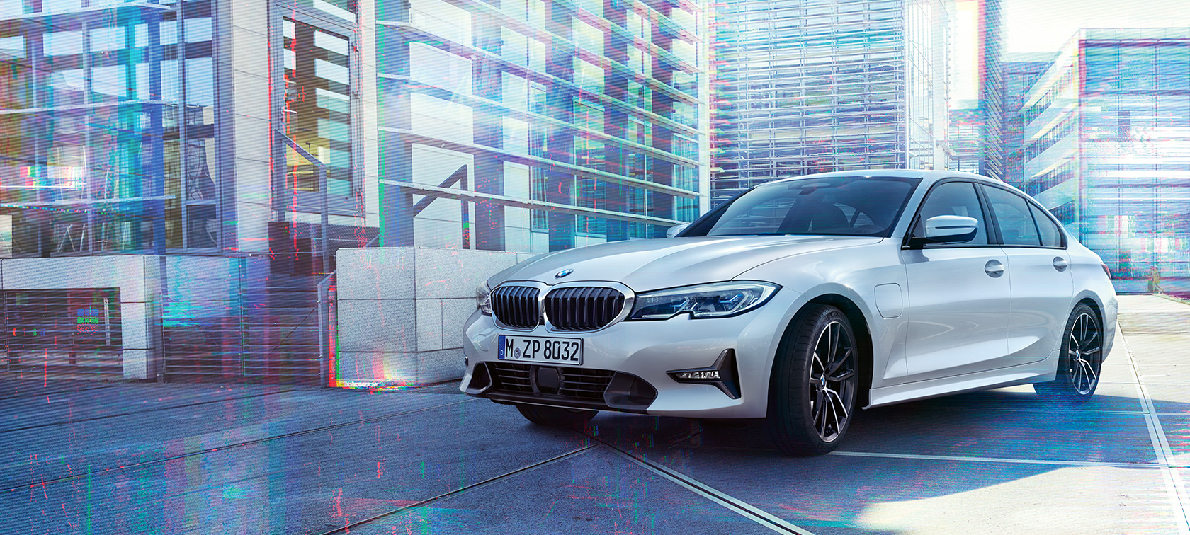 Yeni BMW 3 Serisi Sedan 330e. Şehir arka planı önünde Yeni BMW 3 Serisi Sedan 330e modelinin önden görünümü.