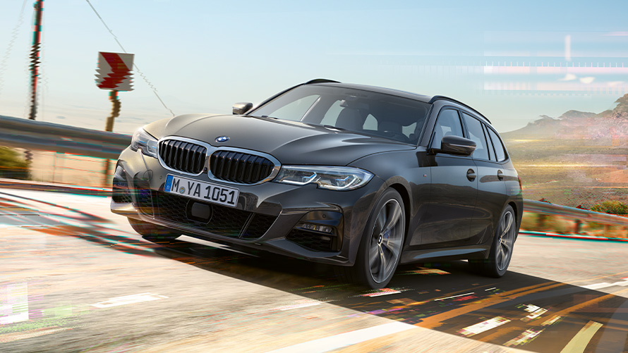 BMW 3 Serisi Touring (G21), Metalik Gri/Dravite, ön çaprazdan görünüm BMW 3 Serisi Touring (G21), Metalik Gri/Dravite, kır manzarası önünde sürüş esnasında çekilmiş ön çaprazdan görünüm