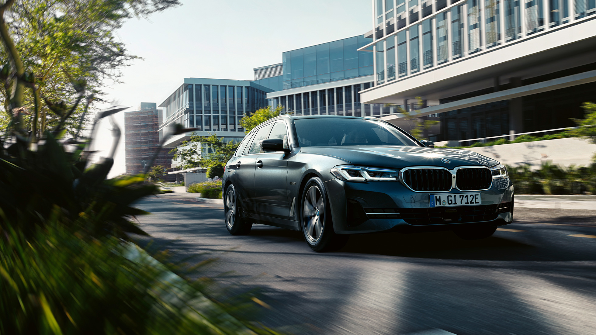 BMW 5 Serisi Touring G31 LCI, Metalik Gri/Sophisto, şehirde seyir halinde önden görünüm BMW 5 Serisi Touring G31 LCI, Metalik Gri/Sophisto, şehirde seyir halinde önden görünüm