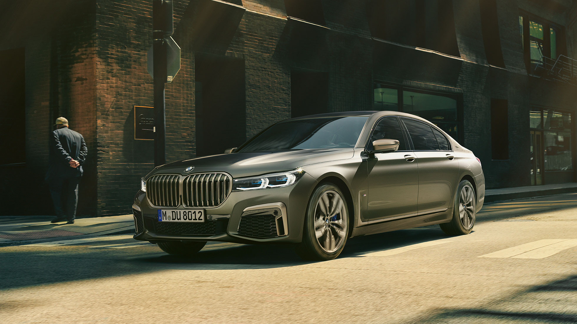 BMW M760Li xDrive şehir içinde BMW M760Li xDrive’ın şehir içinde yolda seyir halinde önden yan görünümü
