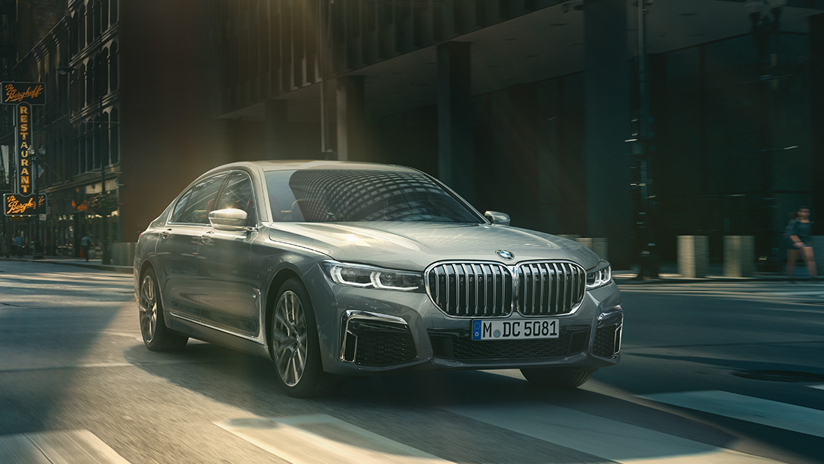 BMW 7 Serisi Sedan, Profesyonel Sürüş Asistanı. Profesyonel Sürüş Asistanı: BMW 7 Serisi Sedan şehir manzarası önünde seyir halinde, önden görünüm.