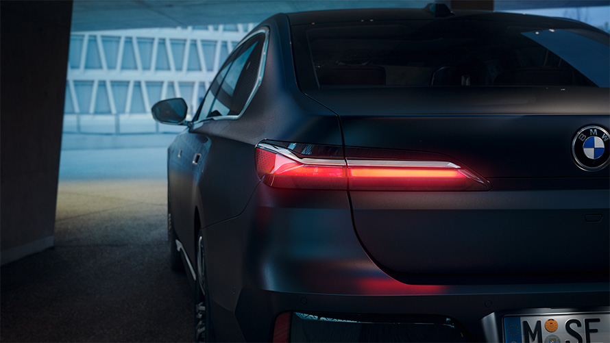 BMW 7 Serisi Sedan G70 ICE 740i M Sport donanımı, Metalik Mat Koyu Gri, kırmızı renkte parlayan stop lambası ile tünelde arkadan görünüm