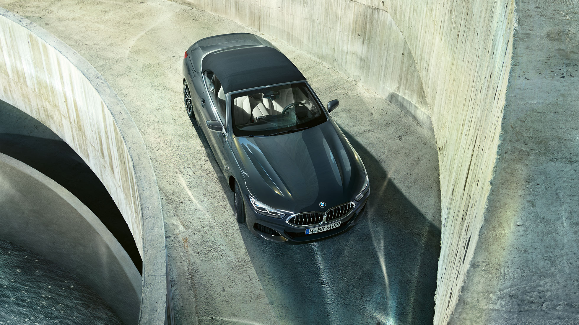BMW M850i xDrive, siyah softtop ile Metalik Gri/Dravit, kuşbakışı görüntüsü. BMW M850i xDrive, siyah softtop ile Metalik Gri/Dravit, kuşbakışı görüntüsü.
