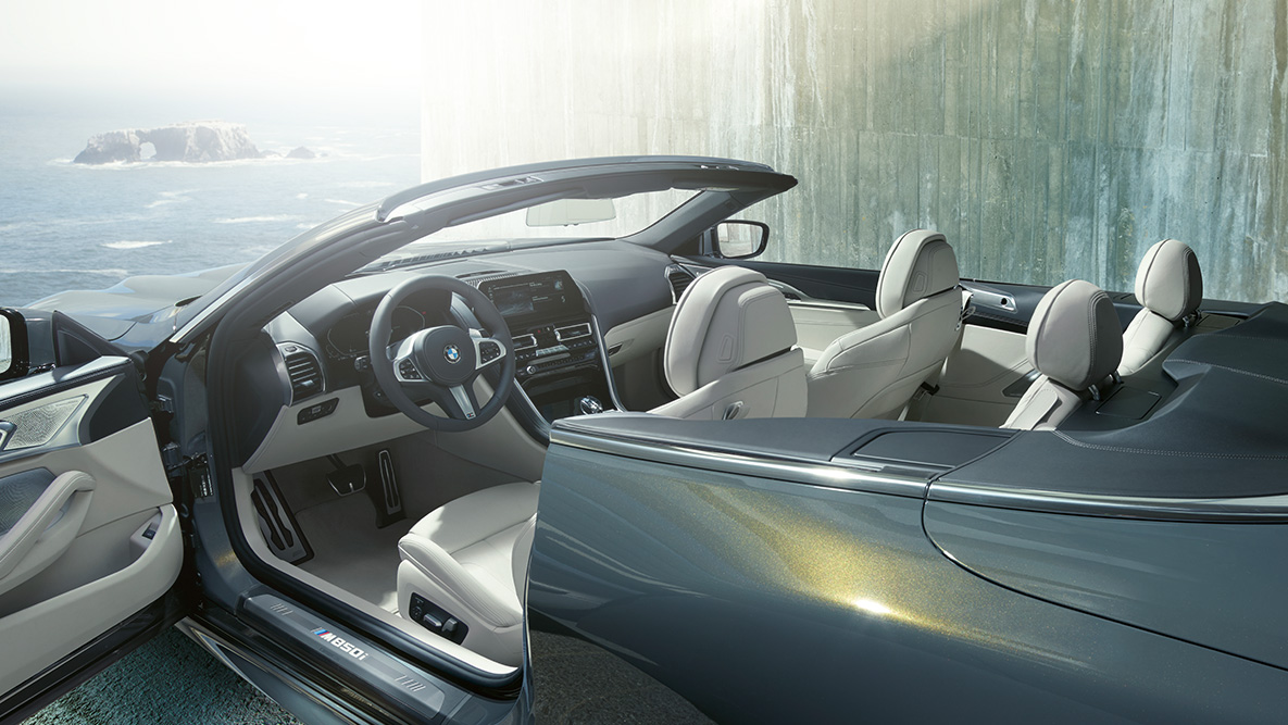 BMW M850i xDrive, Metalik Gri/Dravit, iç tasarım, softtop ve açık kapı. BMW M850i xDrive, Metalik Gri/Dravit, iç tasarım, softtop ve açık kapı.