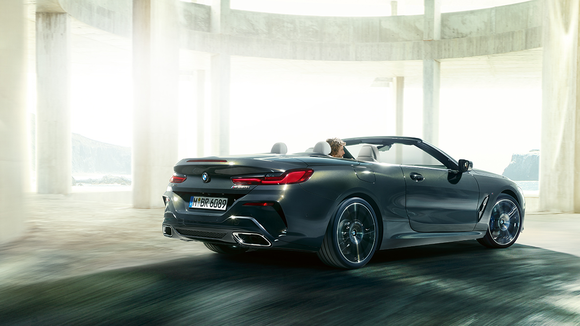 BMW M850i xDrive, tavan açık olarak hareket halindeyken yandan görünüm. BMW M850i xDrive, softtop tavan açık olarak hareket halindeyken yandan görünüm.