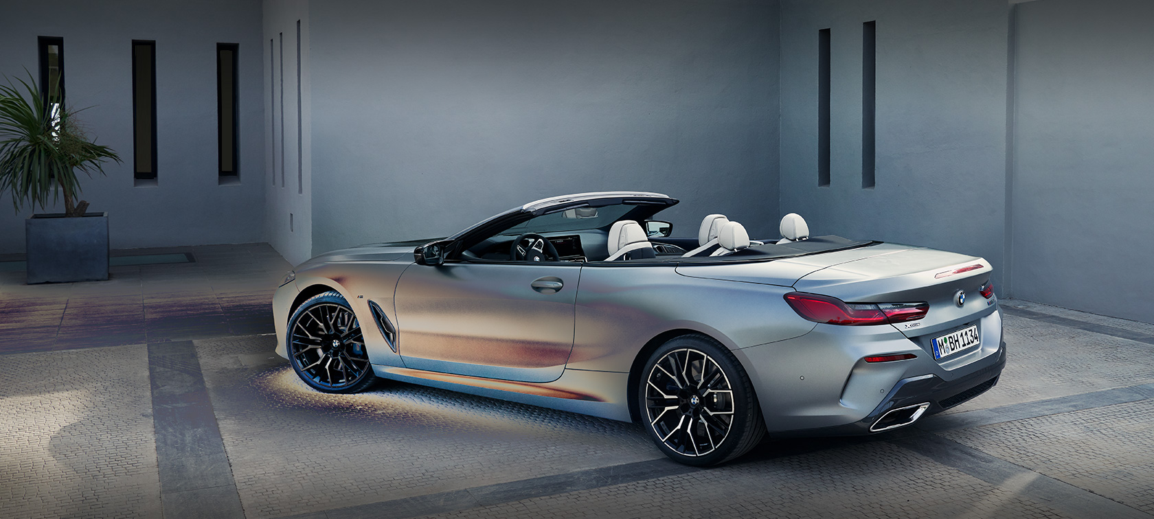BMW 8 Serisi Cabrio G14 LCI, BMW Individual Metalik Mat Gri/Pure Grey, otomobile yaslanan erkek modelle birlikte bir binanın önünde yandan görünüm