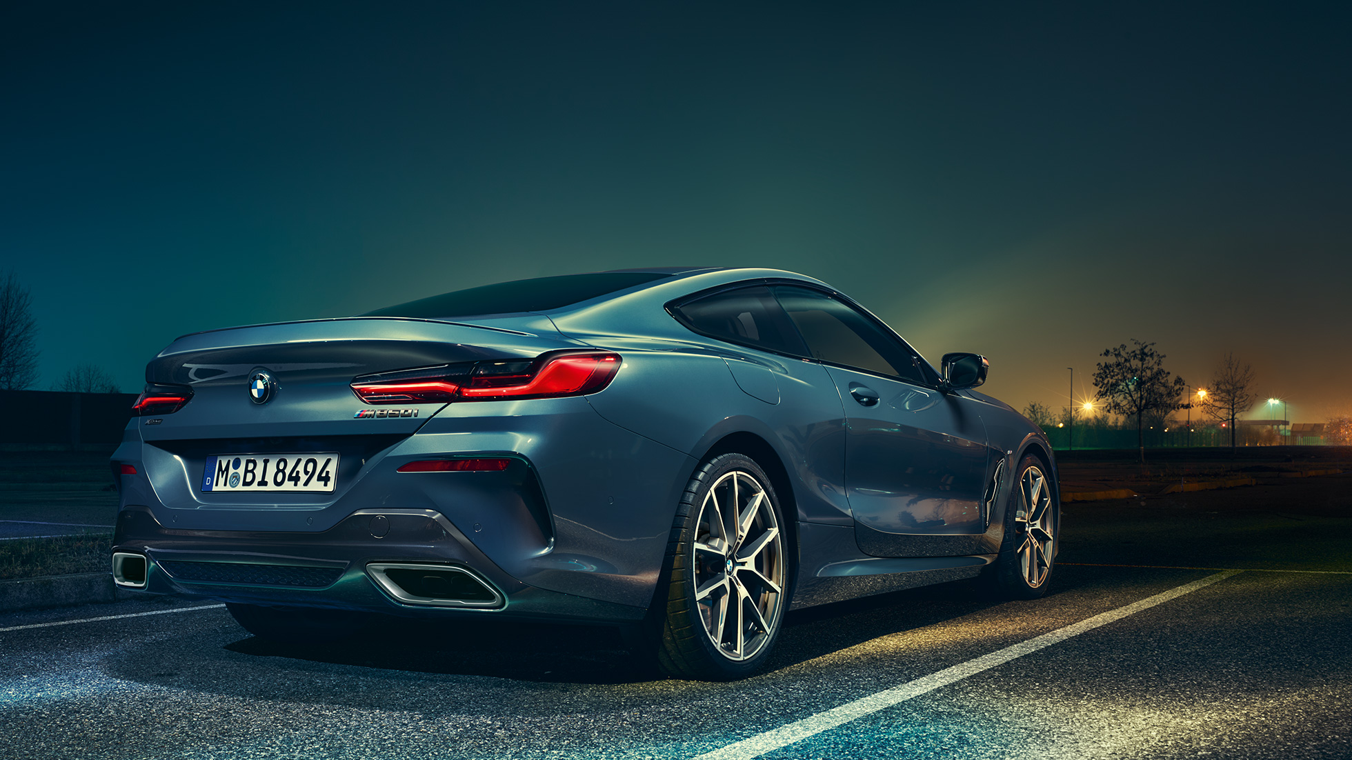 BMW 8 Serisi Coupé, arkadan görünüm. BMW 8 Serisi Coupé, gece manzarası önünde hareketsiz halde, arkadan görünüm.