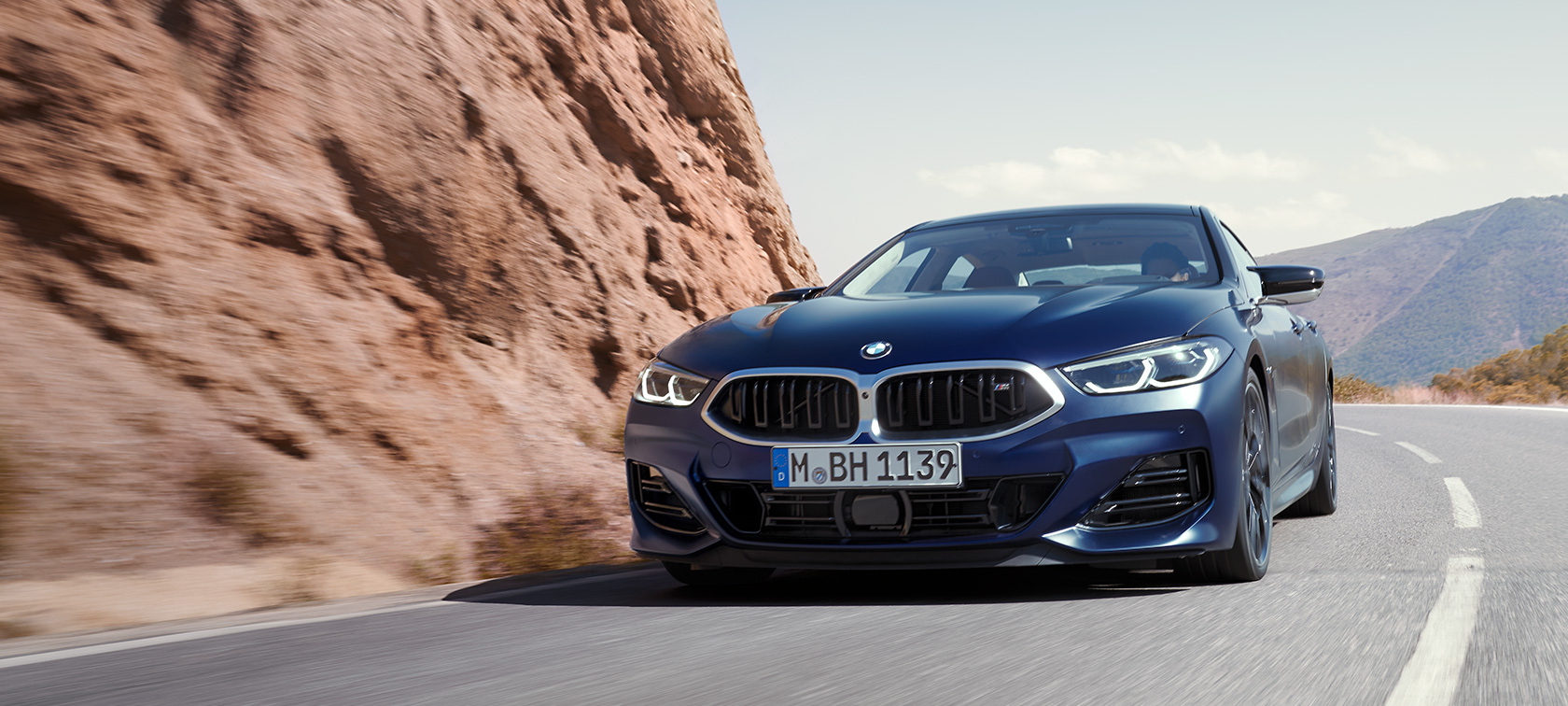 BMW 8 Serisi Gran Coupé G16 LCI, BMW Individual Metalik Mat Mavi/Tanzanite, dağ yolunda sürüş halinde ön çaprazdan görünüm