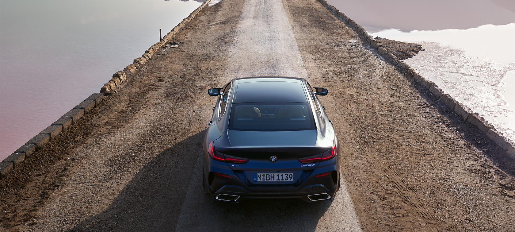 BMW 8 Serisi Gran Coupé G16 LCI, Bina önünde duran BMW Individual Metalik Mat Mavi/Tanzanite gövde rengindeki ön çaprazdan görünüm BMW 8 Serisi Gran Coupé G16 LCI, Bina önünde duran BMW Individual Metalik Mat Mavi/Tanzanite gövde rengindeki ön çaprazdan görünüm