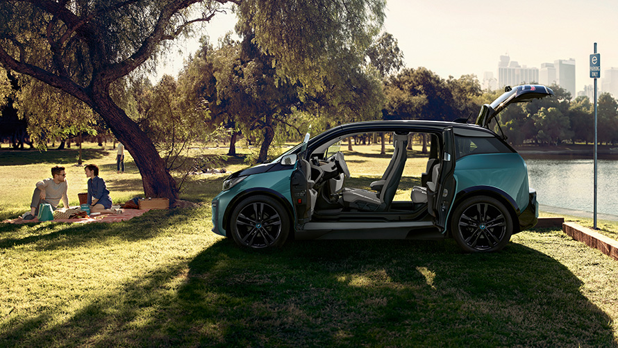 BMW i3 parkta BMW i3 I01 Metalik Mat Gri vurgulu Metalik Bej / Jucaro, parkta kapılar açık halde yandan görünüm
