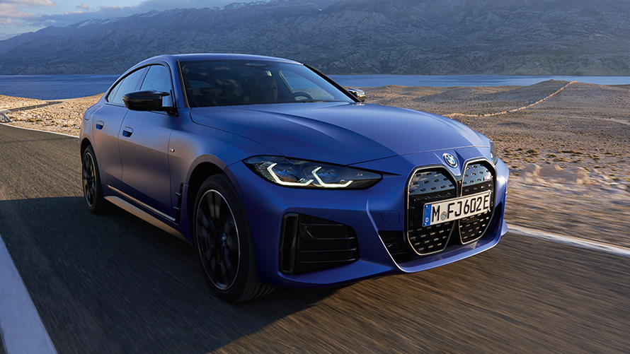 Yeni BMW i4 M50 G26 ön çaprazdan görünüm Yeni BMW i4 M50 G26, M Metalik Mavi/Portimao, yolda sürüş sırasında ön çaprazdan görünüm