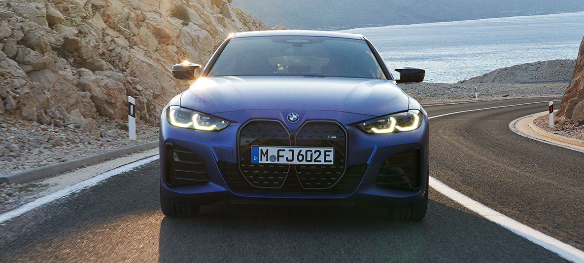 BMW i4 M50 G26, sürüş sırasında önden görünüm BMW i4 M50 G26, M Metalik Mavi/Portimao, yolda sürüş sırasında önden görünüm