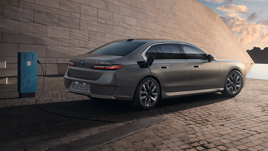 BMW i7 Sedan G70, arka yan çaprazdan görünüm BMW i7 Sedan G70, BMW Individual Metalik Gri/Oxid, şarj istasyonunda arka yan çaprazdan görünüm