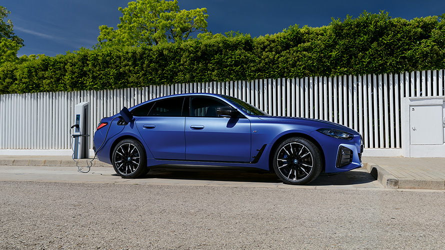 BMW i4 M50 G26, BMW Individual Metalik Mat Mavi/Portimao, şarj direğine bağlıyken yandan görünüm