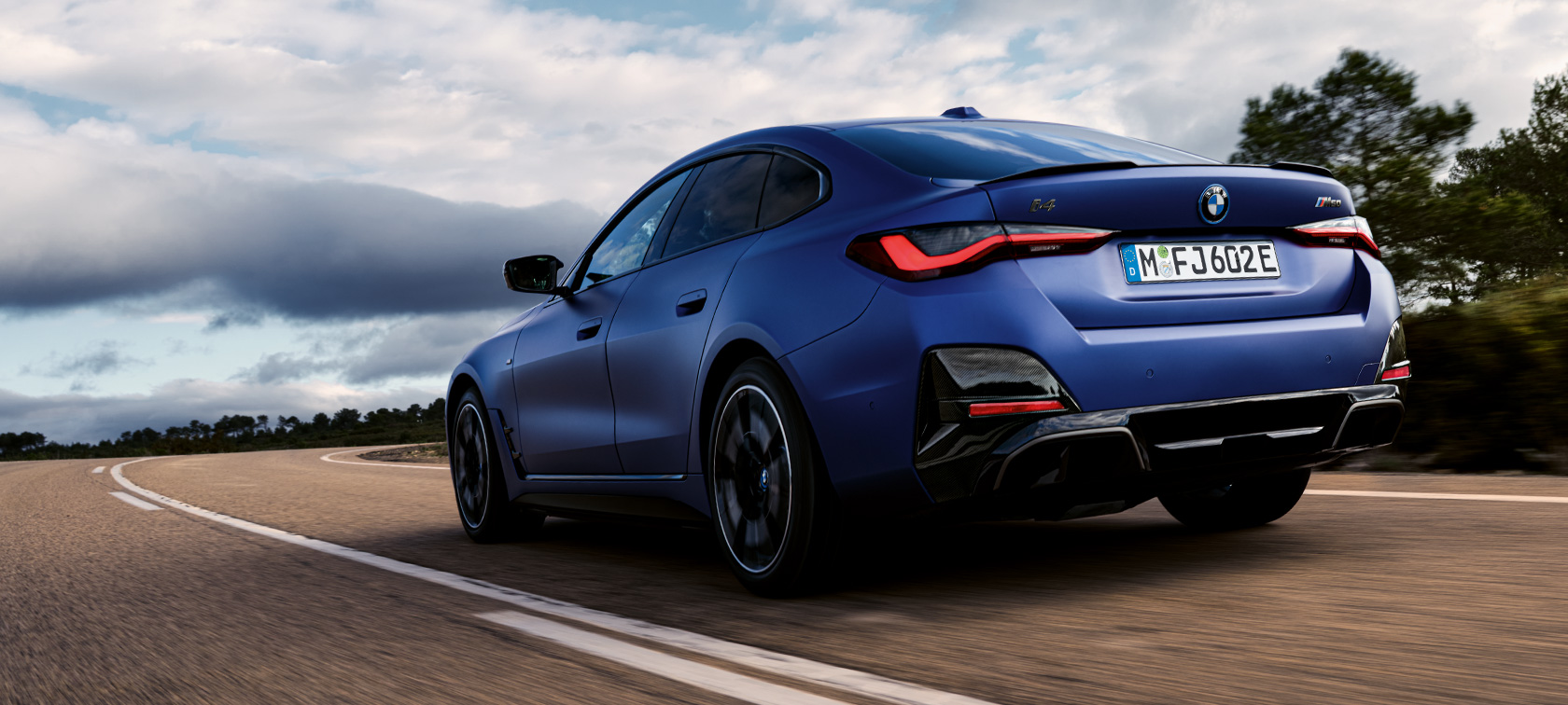 BMW i4 M50 G26, arka çaprazdan görünüm BMW i4 M50 G26, BMW Individual Metalik Mat Mavi/Portimao, sürüş sırasında arka çaprazdan görünüm