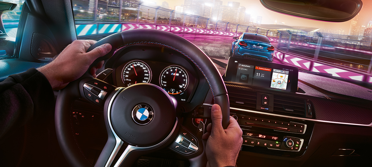Yeni BMW M2 Competition kokpiti İki adet Yeni BMW M2 Competition otomobil gece yarış halinde, kokpitten görünüm.