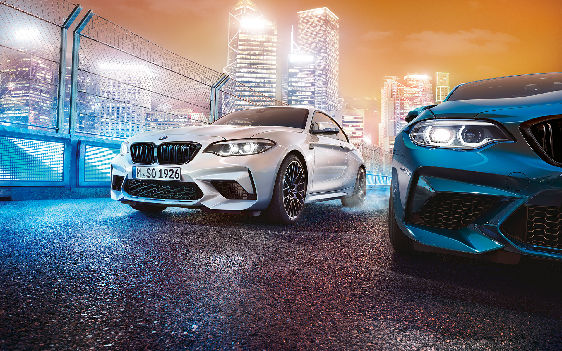 Üç adet Yeni BMW M2 Competition otomobilin önden görünümü Üç adet Yeni BMW M2 Competition otomobil - aydınlatılmış ufuk çizgisi önünde görünüm.