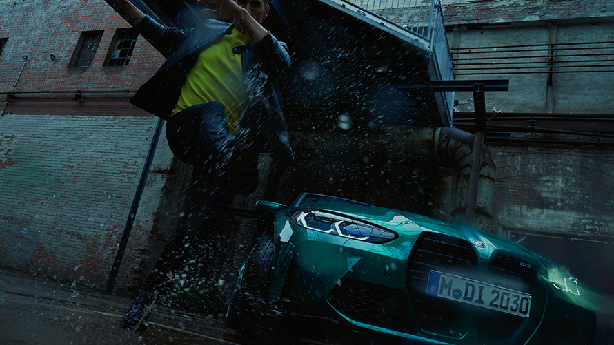 BMW M3 Sedan G80, Metalik Yeşil/Isle of Man, yağmurlu havada bir adam ile birlikte önden görünüm