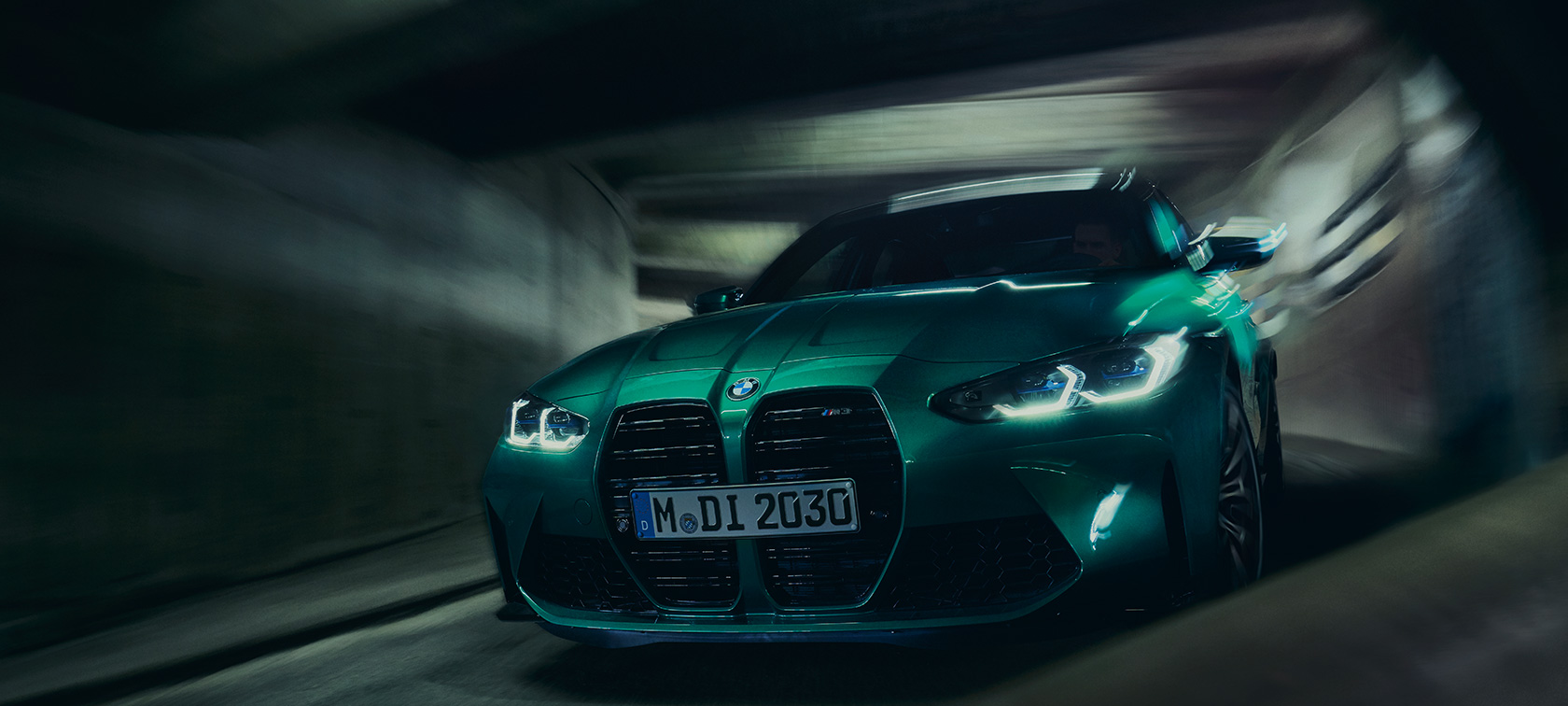 BMW M3 G80, Metalik Yeşil/Isle of Man, sürüş sırasında önden görünüm
