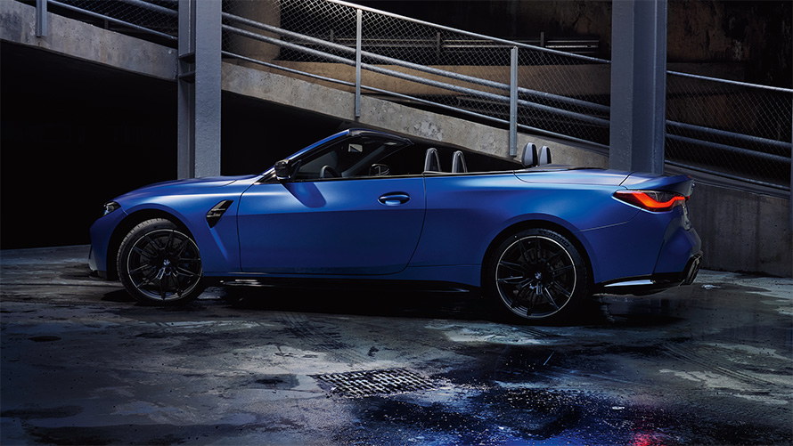 M xDrive özellikli BMW M4 Competition Cabrio G83, softtop tavan açık halde yandan görünüm M xDrive özellikli BMW M4 Competition Cabrio G83, Metalik Mat Mavi/Portimao, softtop tavan açık halde yandan görünüm