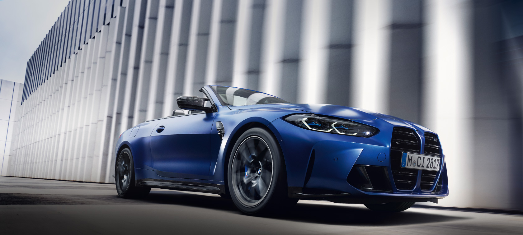 M xDrive özellikli BMW M4 Competition Cabrio G83, BMW Individual Metalik Mat Mavi/Portimao, hareket halinde ön çaprazdan görünüm