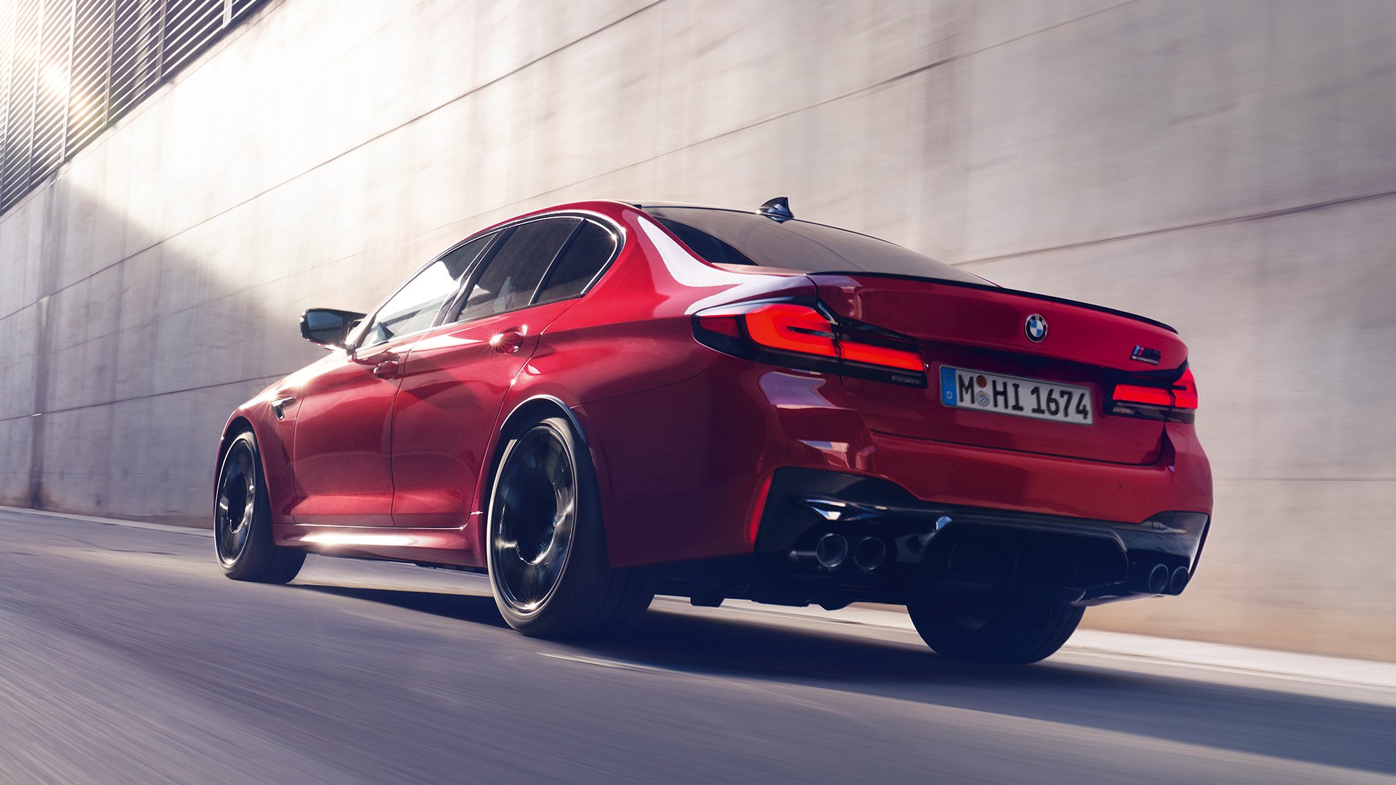 BMW M5 Competition F90 LCI arkadan görünüm BMW M5 Competition F90 LCI BMW Individual Imola Kırmızısı sürüş sırasında arkadan görünüm