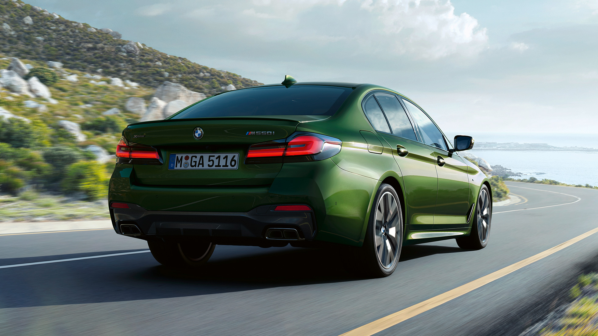 BMW M550i xDrive Sedan G30 LCI arkadan görünüm BMW M550i xDrive Sedan G30 LCI BMW Individual Metalik Yeşil/Verde Ermes otoyolda sürüş sırasında arkadan görünüm