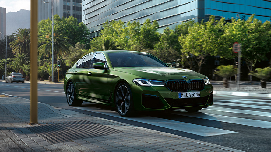 BMW M550i xDrive Sedan G30 LCI BMW Individual Metalik Yeşil/Verde Ermes sürüş sırasında ön çaprazdan görünüm