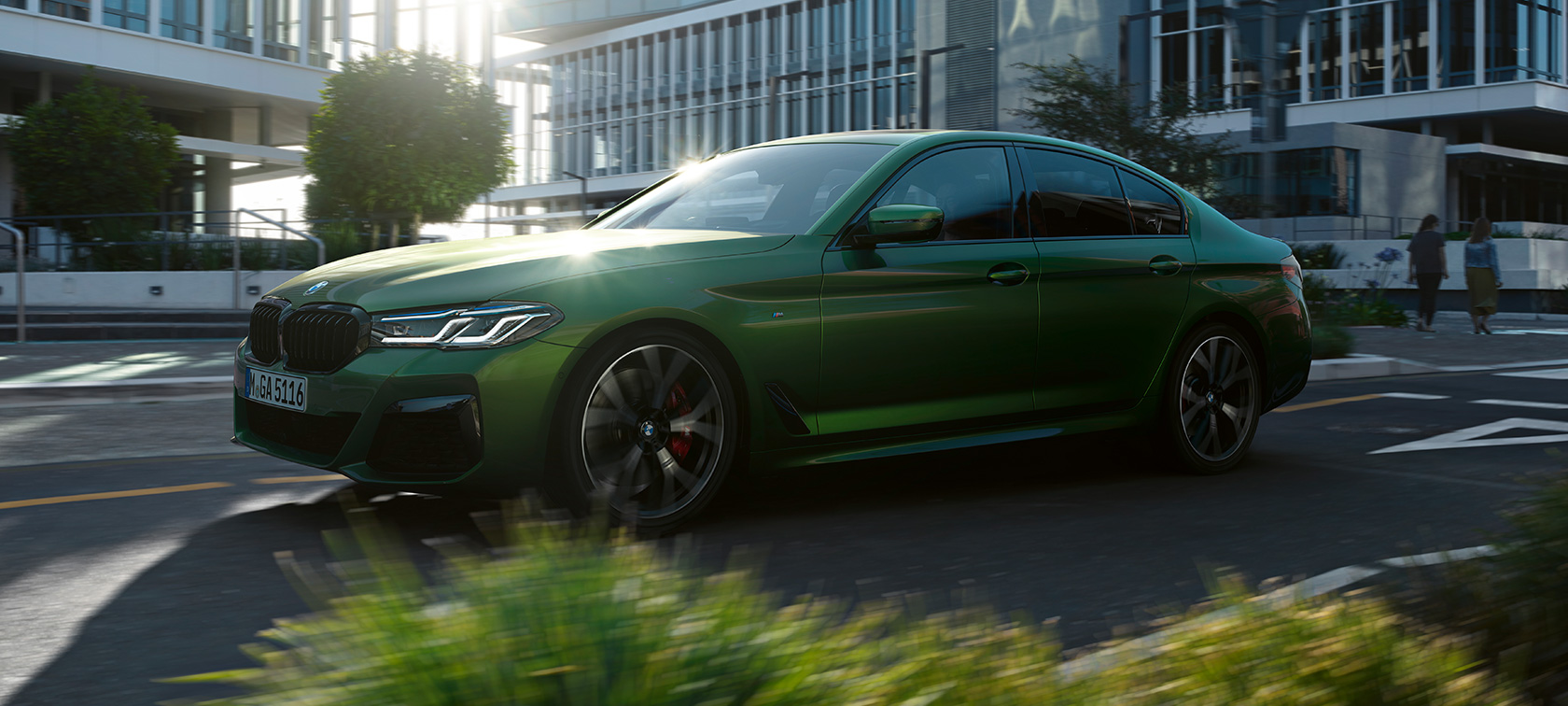 BMW M550i xDrive Sedan G30 sürüş sırasında yandan görünüm BMW M550i xDrive Sedan G30 LCI BMW Individual Metalik Yeşil/Verde Ermes sürüş sırasında yandan görünüm