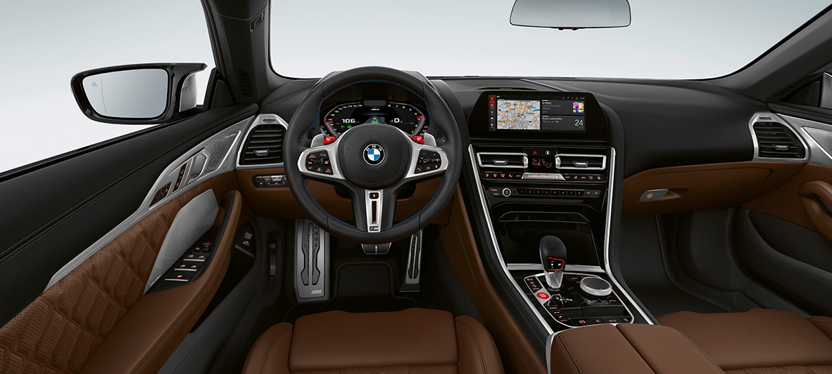 BMW M8 Cabrio, kokpit. BMW M8 Cabrio, M deri direksiyon ve kırmızı M1/M2 düğmelerini içeren BMW M8 kokpit.