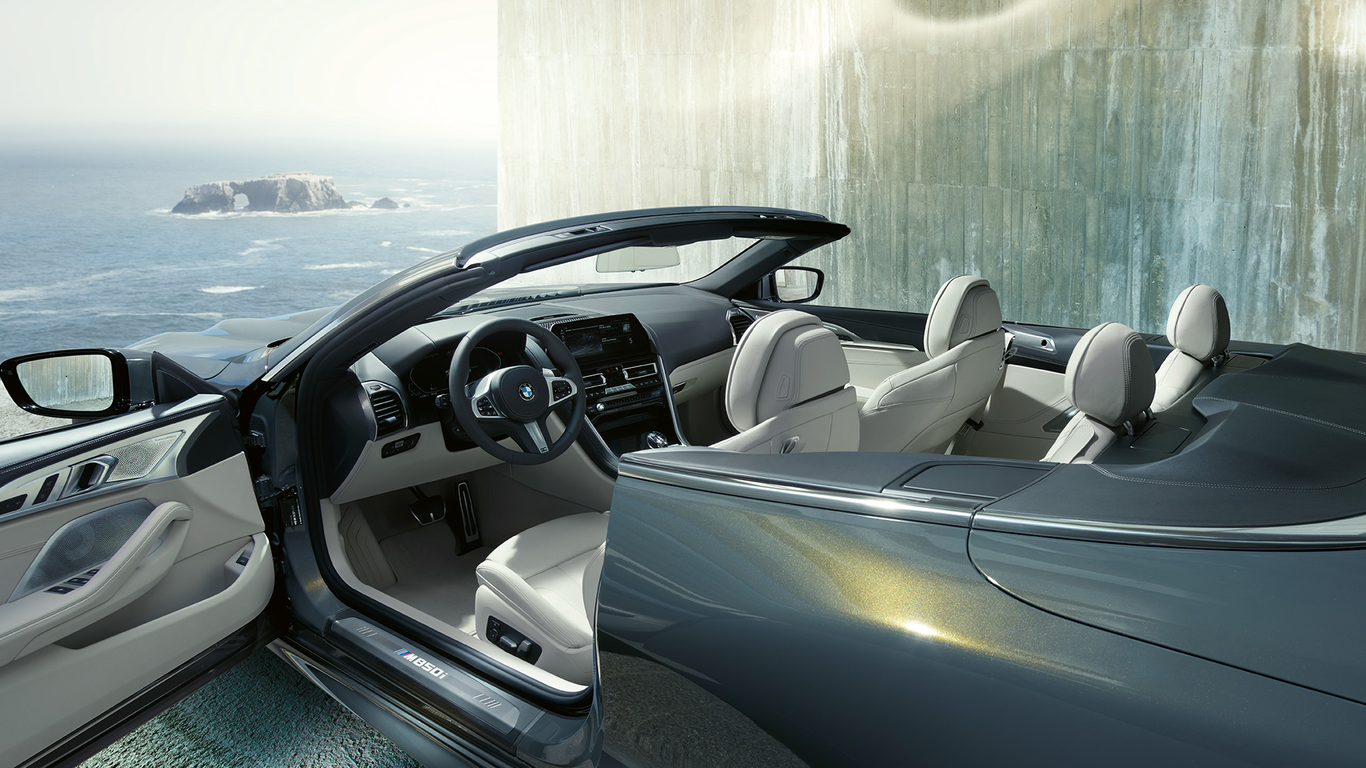 BMW M850i xDrive Cabrio, iç tasarım. Açık softtop ile metalik Gri/Dravit BMW M850i xDrive Cabrio, M deri direksiyon ve Fildişi Beyazı “Merino” BMW Individual deri döşemeyi içeren iç tasarım.