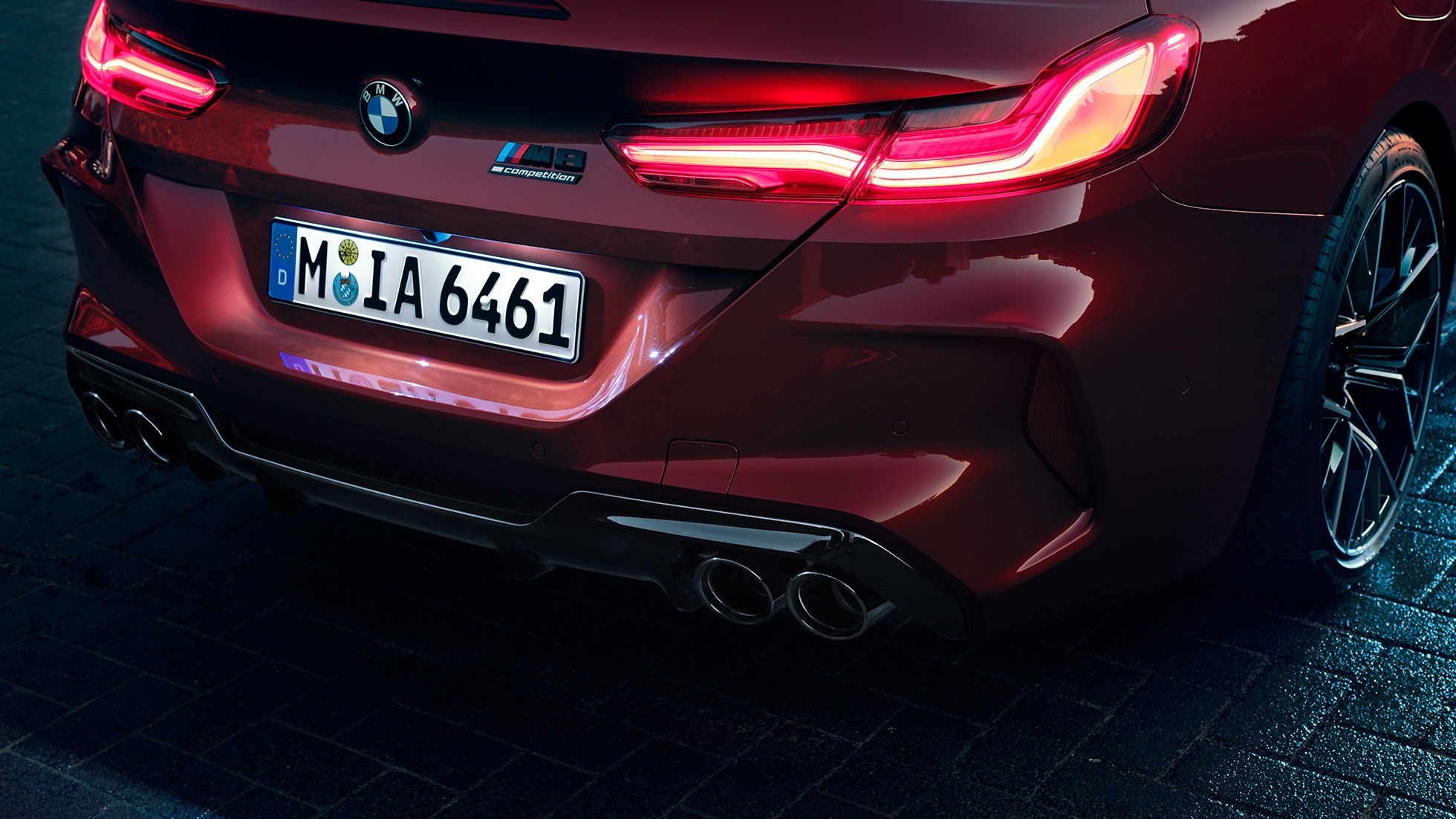 BMW M8 Competition Cabrio, yakın çekim. Metalik Kırmızı/Motegi BMW M8 Competition Cabrio, LED stop lambaları ve M8 Competition isimliğine yakın çekim.