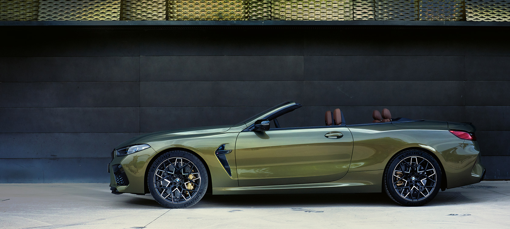 Yeni BMW M8 Competition Cabrio F91, hareketsiz halde yandan görünüm Yeni BMW M8 Competition Cabrio F91 BMW Individual Metalik Pirinç/Brass, kapısı açık ve kadın model ile yandan görünüm