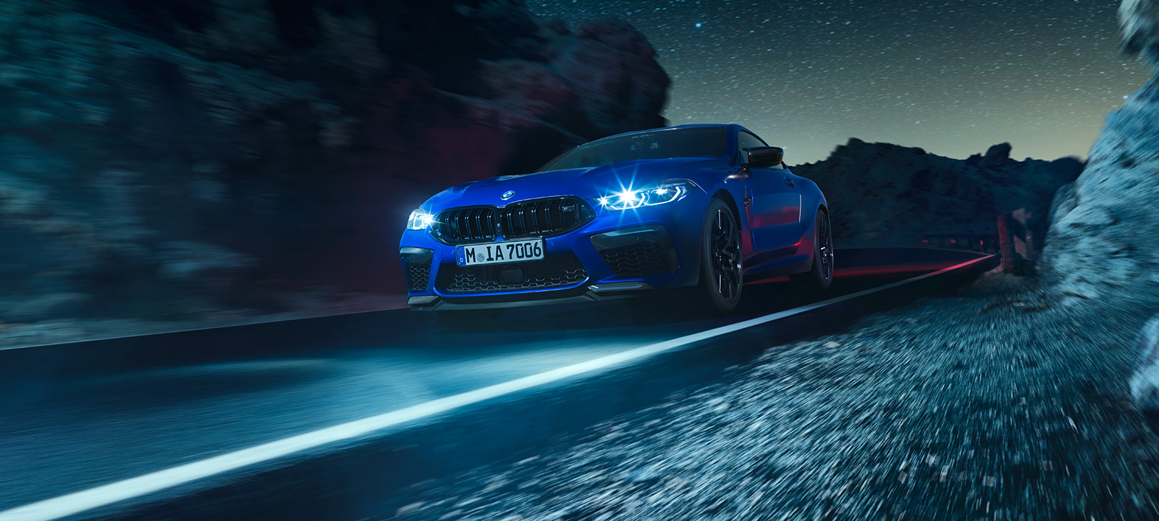 BMW M8 Competition Coupé, önden görünüm. Gece sürüşü sırasında Metalik Mavi/Marina Bay BMW M8 Competition Coupé, önden görünüm.