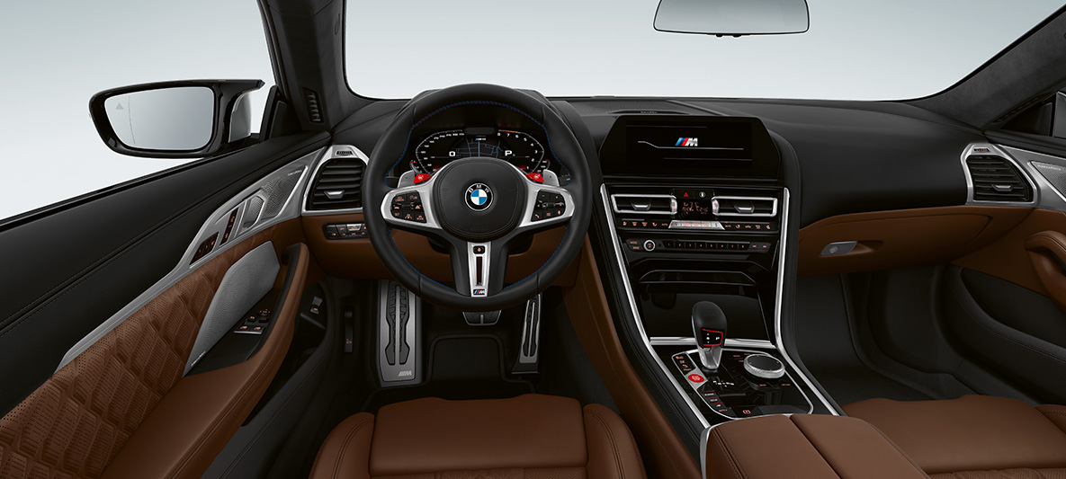 BMW M8 Coupé, kokpit. BMW M8 Coupé, M deri direksiyon ve kırmızı M1/M2 düğmelerini içeren kokpit.