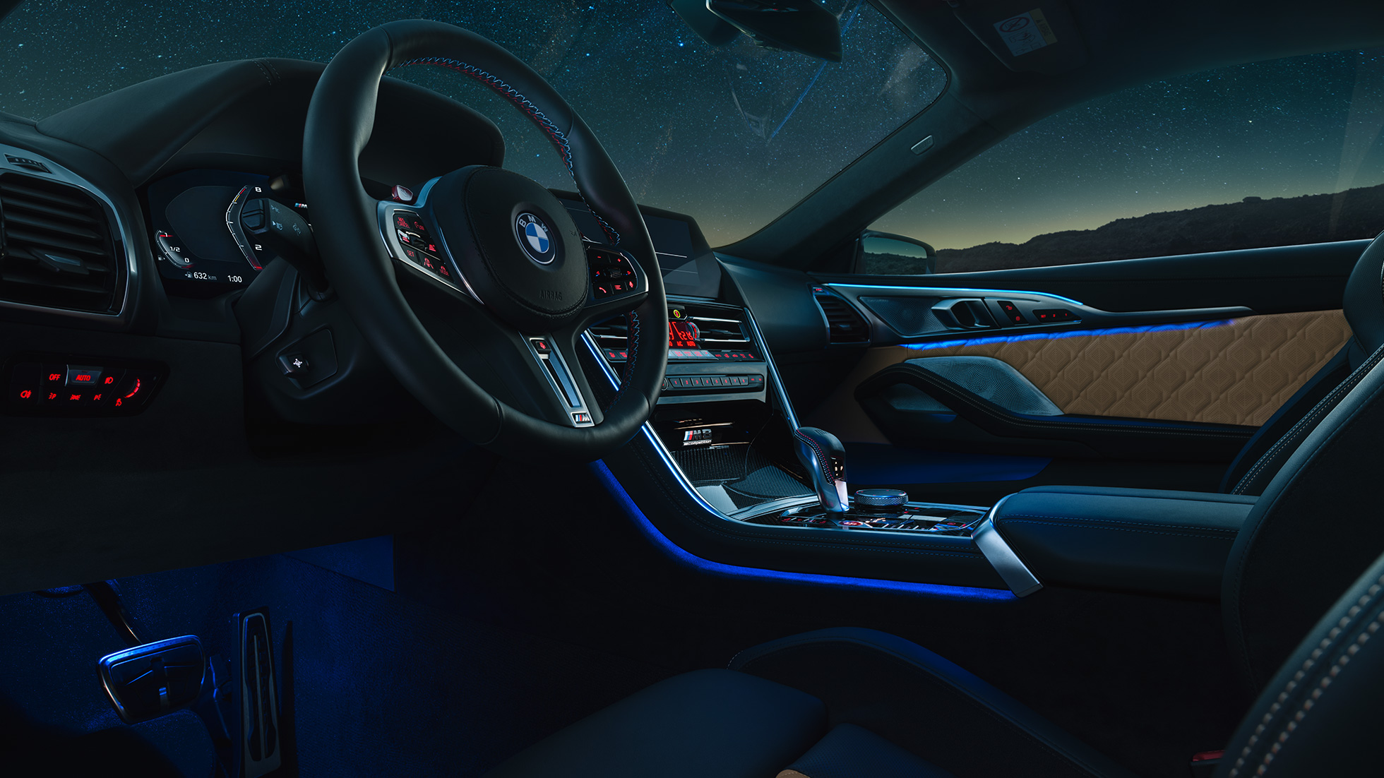 Yeni BMW M8 Competition Coupe, M deri direksiyon ve mavi ortam aydınlatmasıyla kokpitin gece görünümü. Yeni BMW M8 Competition Coupe, M deri direksiyon ve mavi ortam aydınlatmasıyla kokpitin gece görünümü.
