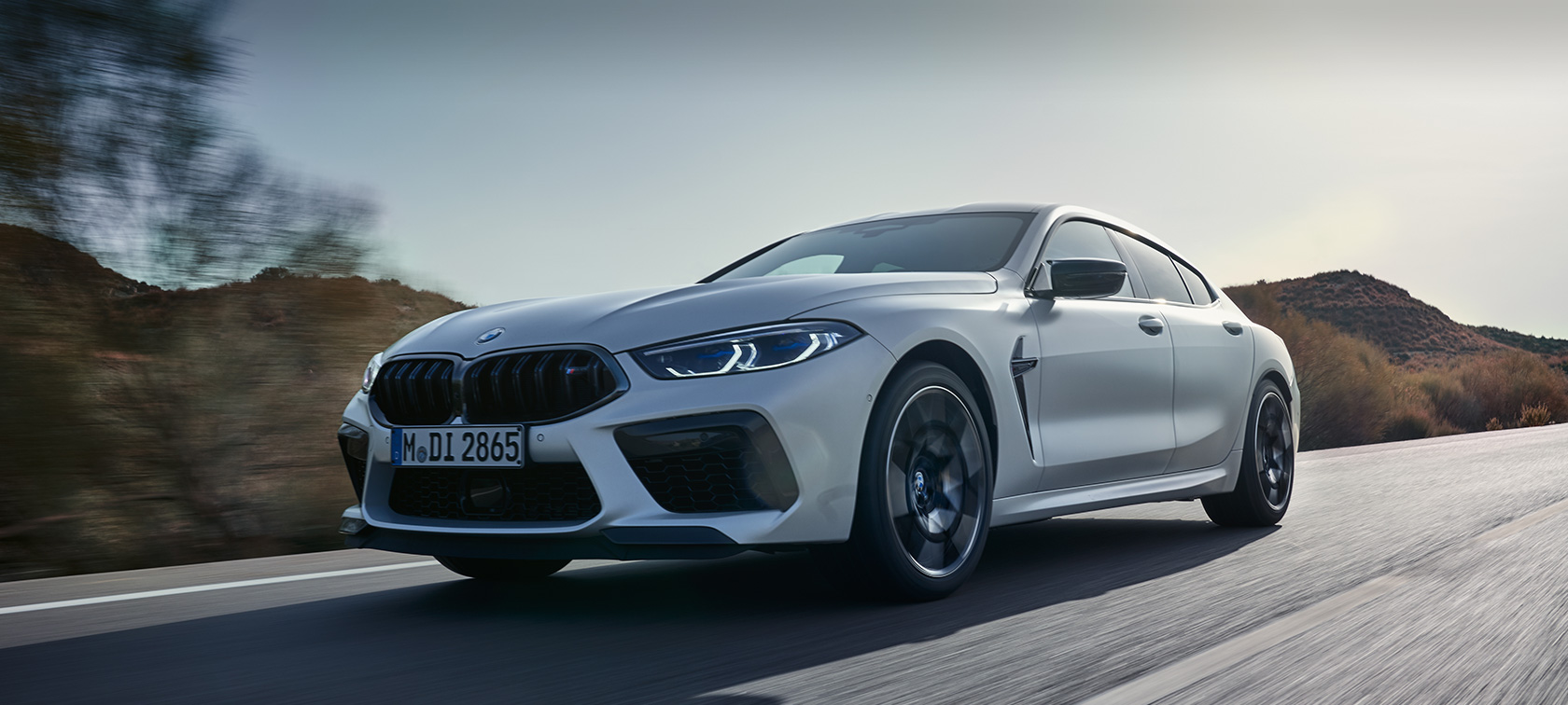 BMW M8 Competition Gran Coupé F93 BMW Individual Metalik Beyaz/Frozen Brilliant sürüş sırasında ön çaprazdan görünüm