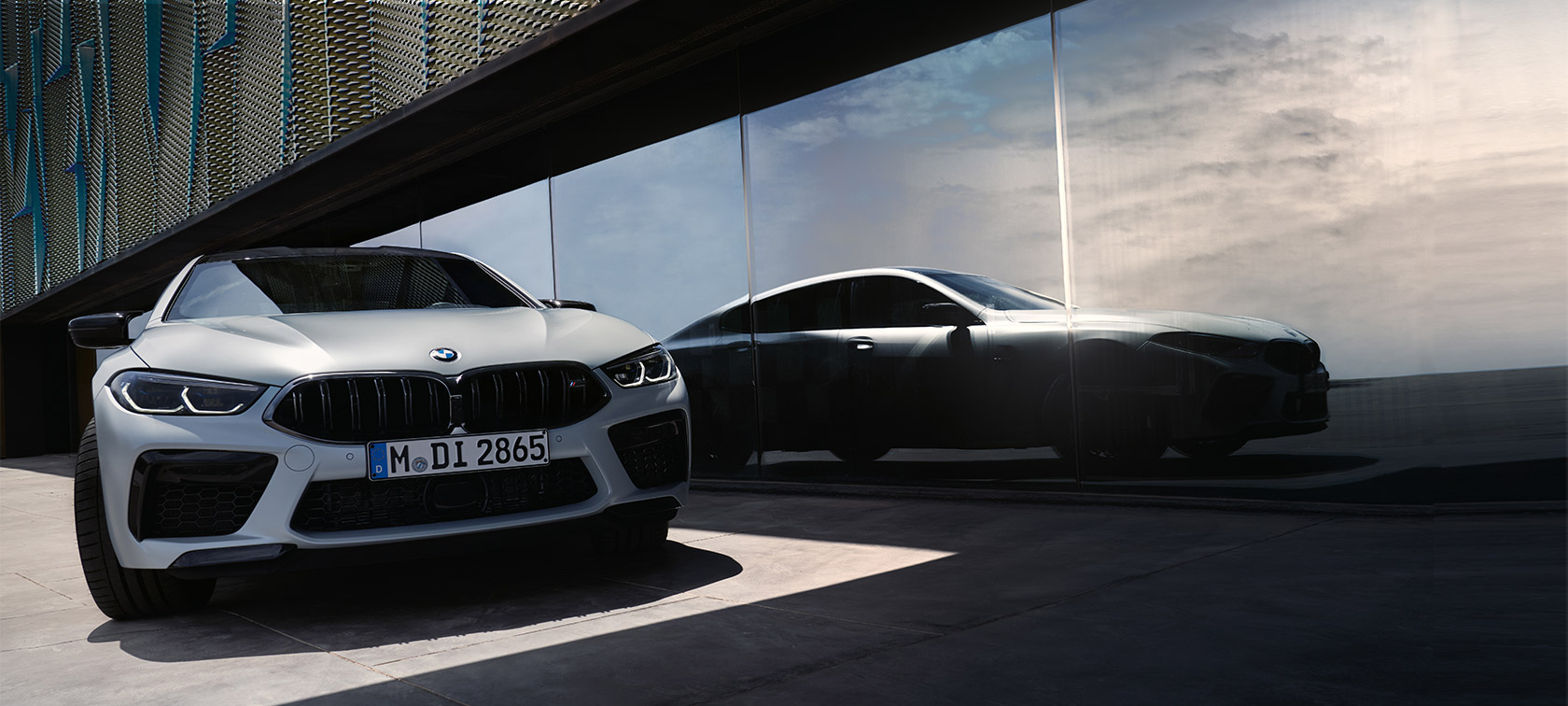 BMW M8 Competition Gran Coupé F93, önden görünüm BMW M8 Competition Gran Coupé F93 BMW Individual BMW Individual Metalik Beyaz/Frozen Brilliant ön cam üzerinde bir siluet yansımasıyla önden görünüm