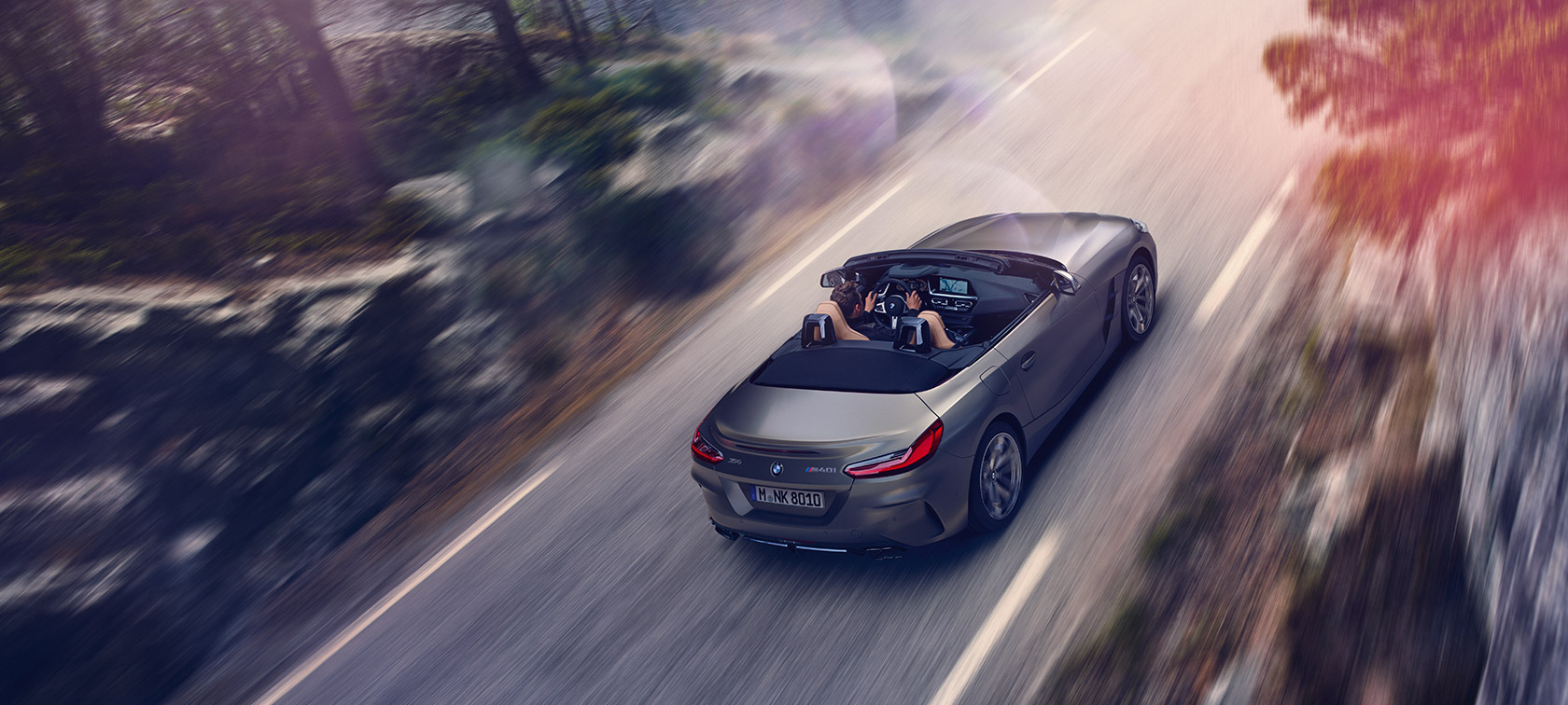 Gri gövde renginde BMW Z4 Roadster’ın kuş bakışı görünümü Gri gövde renginde BMW Z4 Roadster’ın hareket halinde kuş bakışı görünümü