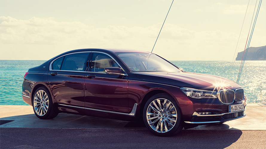 Nautor’s Swan’dan ilham alan BMW Individual M760Li G12, koydaki bir iskelede yelkenlinin önünde yan çaprazdan görünüm