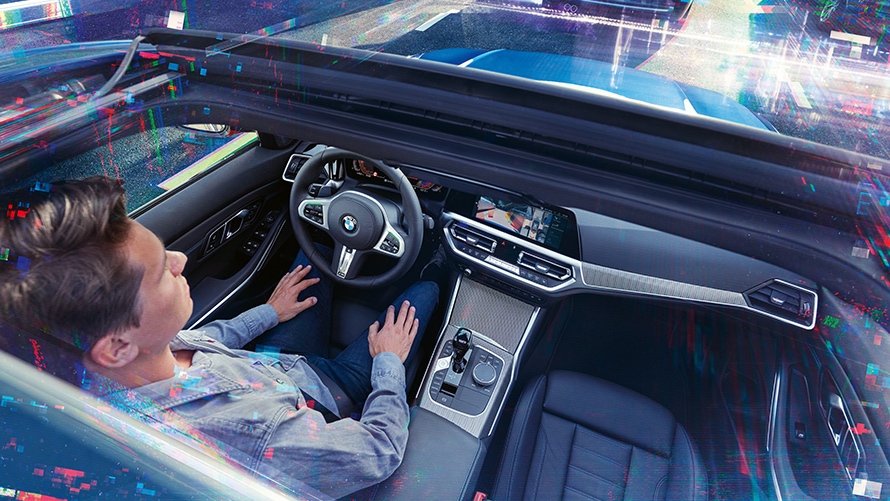 BMW Kişisel Yardımcı Pilot: Akıllı Park BMW Kişisel Yardımcı Pilot park asistanı kullanılarak park edilen bir BMW’de oturan sürücü.