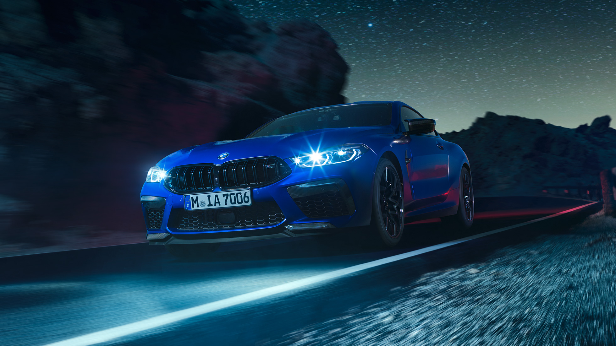 BMW M8 Competition Coupé sürüş sırasında, önden görünüm. Parlak LED farlarıyla gece sürüşü sırasında Metalik Mavi/Marina Bay BMW M8 Competition Coupé, önden görünüm.