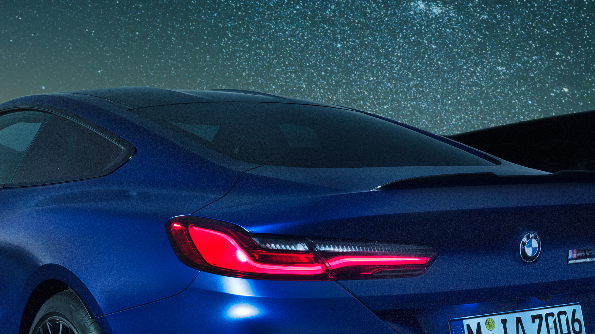 M arka spoyler Karbon M arka spoyler ile birlikte omuz kısmının gece yakından görünümüyle Metalik Mavi/Marina Bay BMW M8 Competition Coupé.