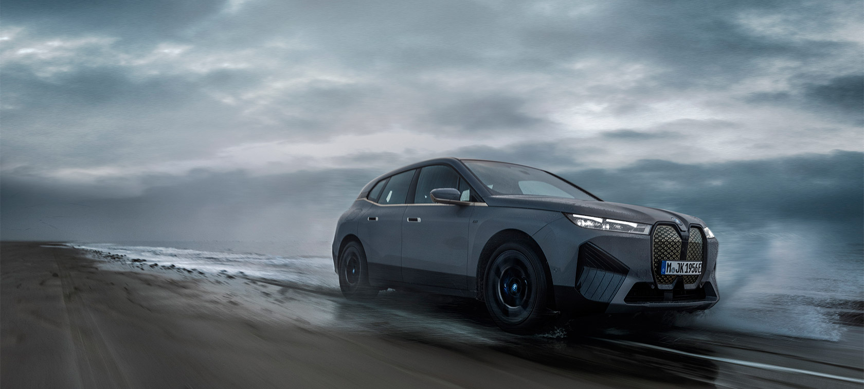 BMW iX M60 i20 2022 elektrikli SUV BMW Individual metalik Storm Bay BMW Wallbox ile evin önünde şarj oluyor, önden görünüm